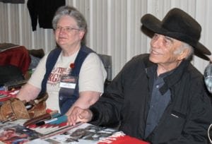 James Drury, also known as the Virginian, sits next to his assistant Karen Lindsey and signs autographs and greets event goers.